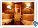 Two twin beds on forward Guest Stateroom. Foreward Head (bathroom) in center background.